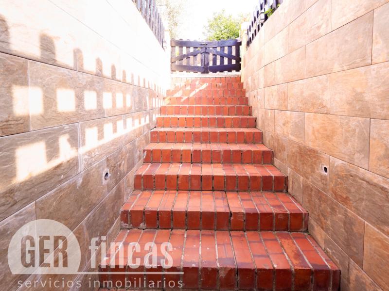 Casa de cuatro vientos con jardín y planta superior diáfana · Escalera