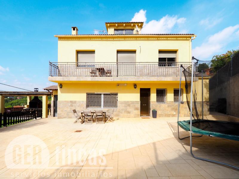 Casa de cuatro vientos con jardín y planta superior diáfana · Fachada
