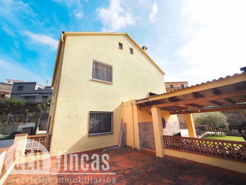 Casa de cuatro vientos con jardín y planta superior diáfana · Fachada