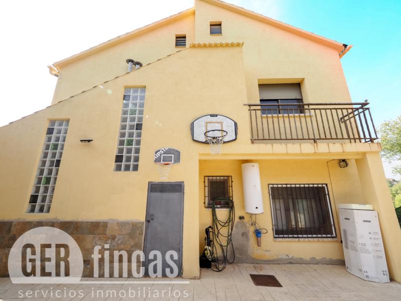 Casa de cuatro vientos con jardín y planta superior diáfana · Fachada