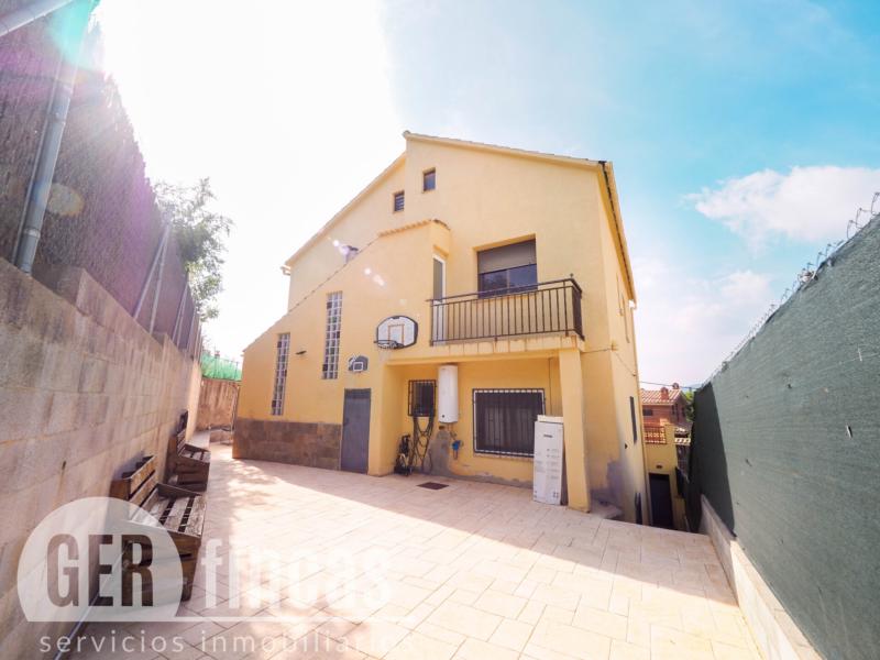 Casa de cuatro vientos con jardín y planta superior diáfana · Fachada