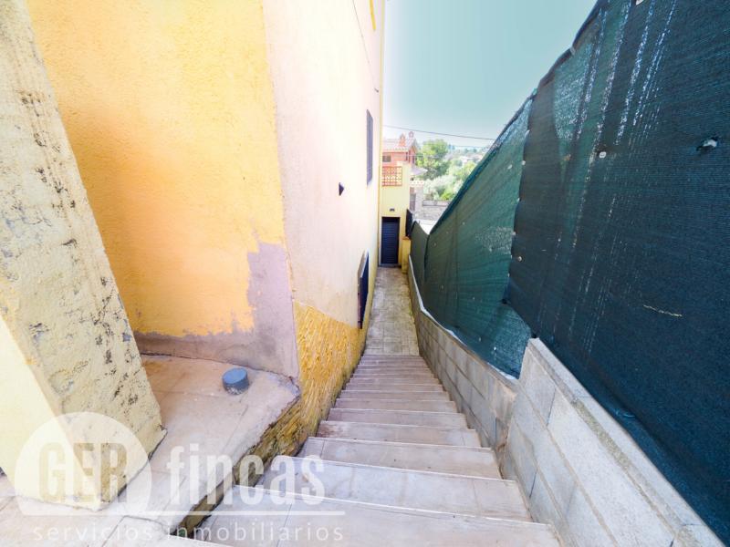 Casa de cuatro vientos con jardín y planta superior diáfana · Escalera